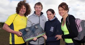 Richie Clifford, Hector Ó hEochagáin, Kitty Quinn, and Carmel Clifford look at a picture from one of Richie's first classes in 1996. 
