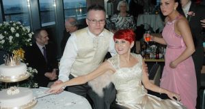 Kathy O'Brien with her husband Glen cutting the cake on their wedding day with daughter Nadine, 21 who was their bridesmaid. Picture: Press 22