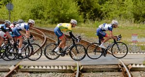 Rob Partridge, Britain UK Youth Pro Cycling, is followed by yellow jersey winner Marcin Bialoblocki over a level crossing at Banteer, Cork. Picture: Paul Mohan / SPORTSFILE