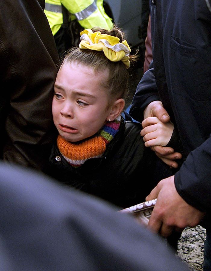 A Catholic schoolgirl is comforted as she makes her way through a massive security operation on her way to Holy Cross school. Picture: AP