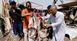 An Iraqi man holds blood-stained clothes at the scene of a bomb attack in Baghdad today.