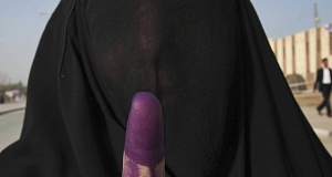 An Iraqi woman displays her inked finger after casting her vote for the parliamentary election in Najaf, Iraq today.