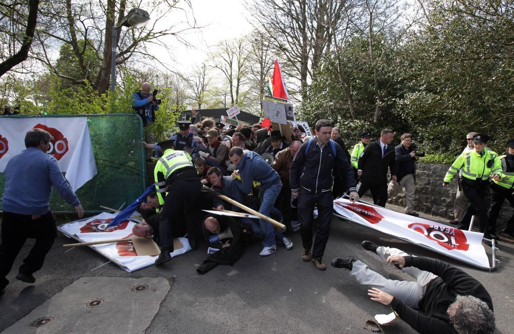 Protesters break through a barrier outside the conference.