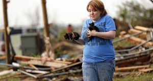 Rachel Hilton holds stray kittens she found in the debris