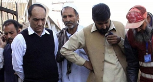People gather at the spot of a suicide bombing outside a courthouse in Peshawar, Pakistan today.