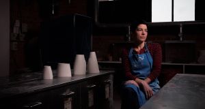 Sara Flynn in her studio with some of her porcelain vessels