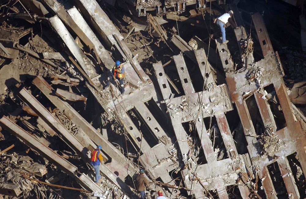 Workers climb over the remains of the twin towers. Picture: AP