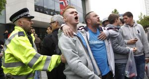 People heckle the Mayor of London, Boris Johnson, not pictured, as he visits the scene of the attack. (AP Photo/Sang Tan)